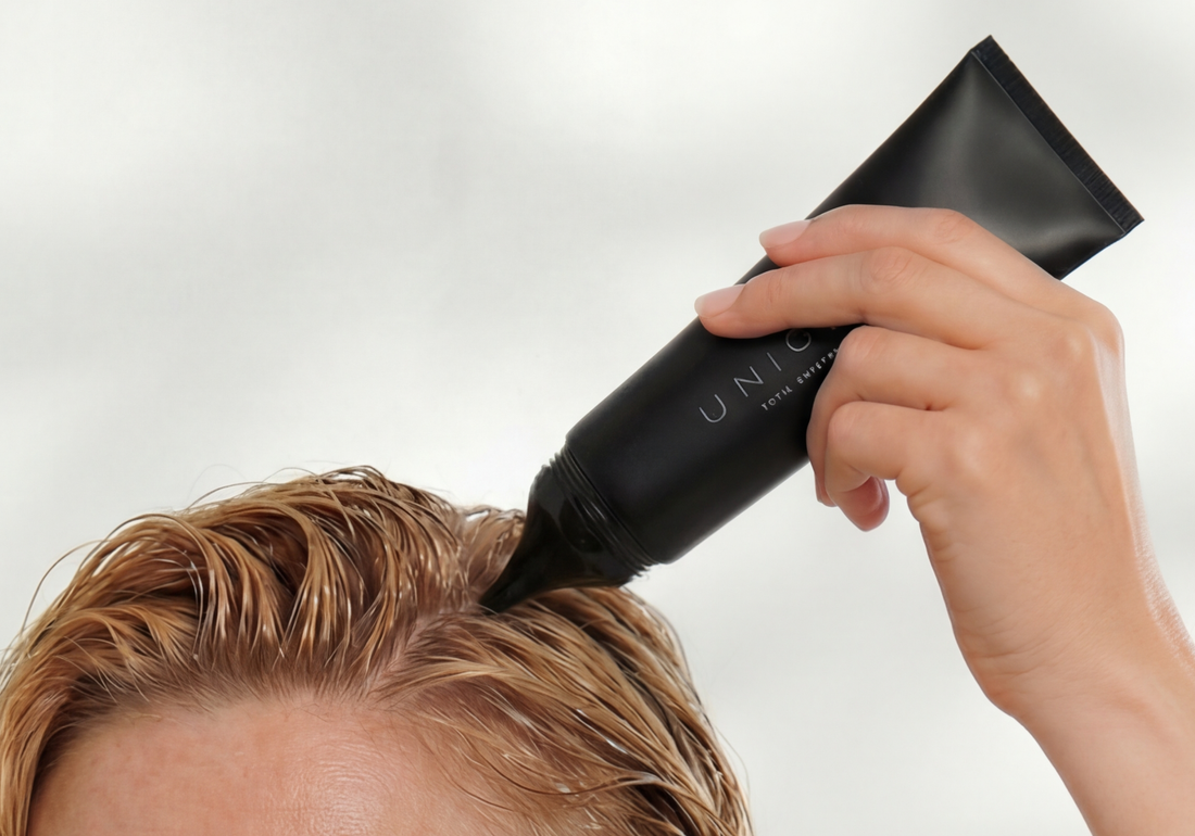 Una mujer aplicando productos capilares de UNICSKIN para tratar el cuero cabelludo seco